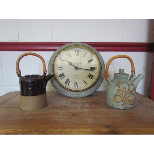 1281 - A modern Knight & Gibbins battery operated wall clock and two pottery teapots (3)