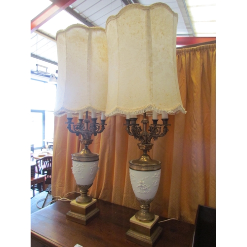 1297 - A pair of American style four candle table lamps, cherubic bodies and ornate gilt scrolled arms on g... 