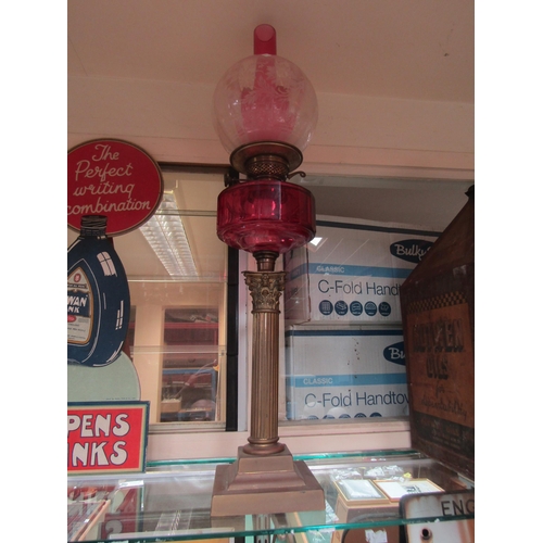 5531 - A Victorian brass column oil lamp with pink glass shade          (R) £100