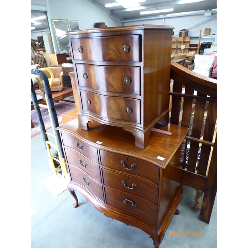 2475 - A reproduction serpentine cabinet as a chest of drawers, raised on scrolled pad feet. A reproduction... 