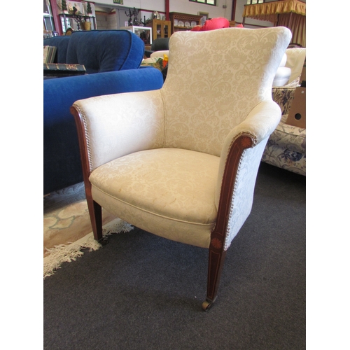 1358 - A Victorian cream upholstered chair on tapering fore legs to brass castors