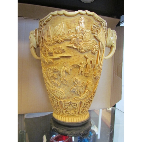 1615 - An Oriental resin vase with figural external scenes and elephant handles on base, 30cm tall