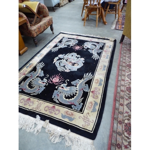 2357 - An oriental blue and black dragon rug