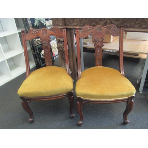 1003 - A pair of Victorian mahogany open armchairs with carved backrests, cabriole fore legs to brass casto... 