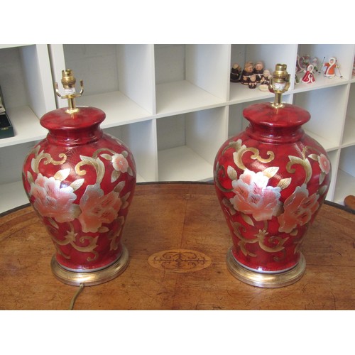 1004 - A pair of modern Oriental-style red lacquered ginger jar form table lamp bases with gilt floral desi... 