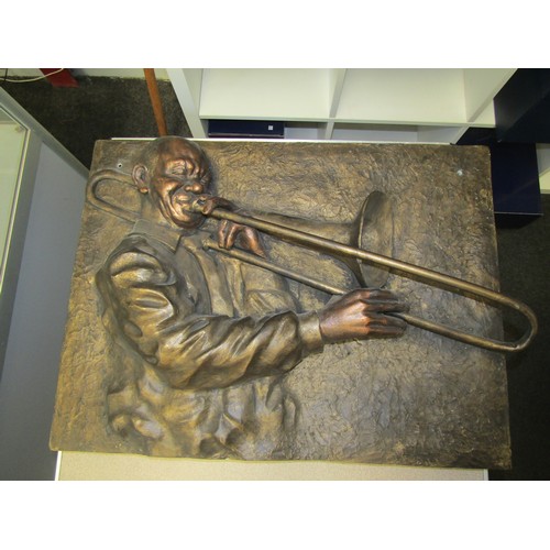 1008 - A bronze-effect 3D wall sculpture depicting jazz trombonist. Damage to top corners verso. 52x70cm