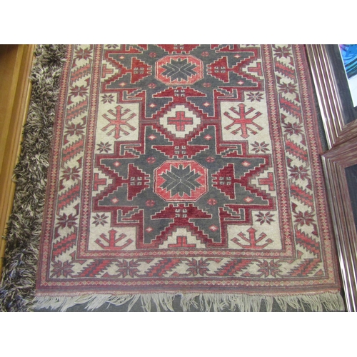 1236 - A Middle-Eastern rug, geometric patterns, tasseled fringe, 188cm x 107cm