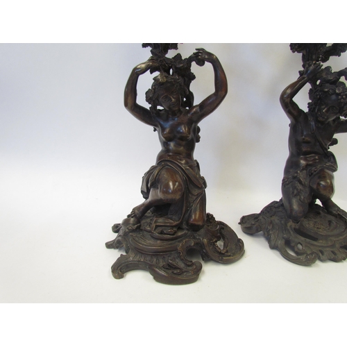 1634 - A pair of early 19th Century bronze figural three branch, four light candelabra in the Rococo style,... 