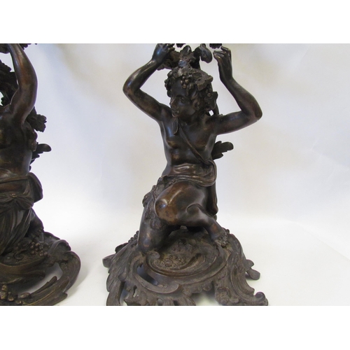 1634 - A pair of early 19th Century bronze figural three branch, four light candelabra in the Rococo style,... 