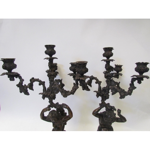 1634 - A pair of early 19th Century bronze figural three branch, four light candelabra in the Rococo style,... 