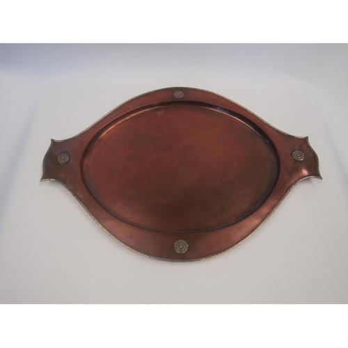 1659 - An Art Nouveau hammered copper dish with silver trim by A.E. Jones, Tudor rose roundels, 51cm long