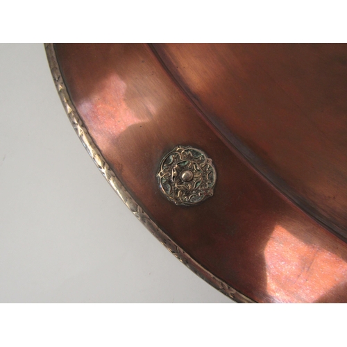 1659 - An Art Nouveau hammered copper dish with silver trim by A.E. Jones, Tudor rose roundels, 51cm long