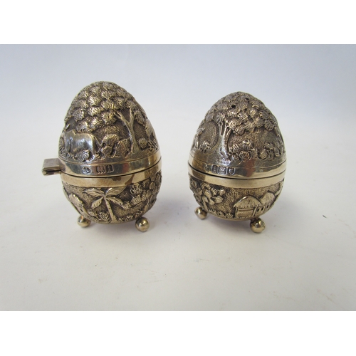 1047 - A pair of silver egg-shaped cruets by William Hutton & Sons with all over decoration depicting trees... 