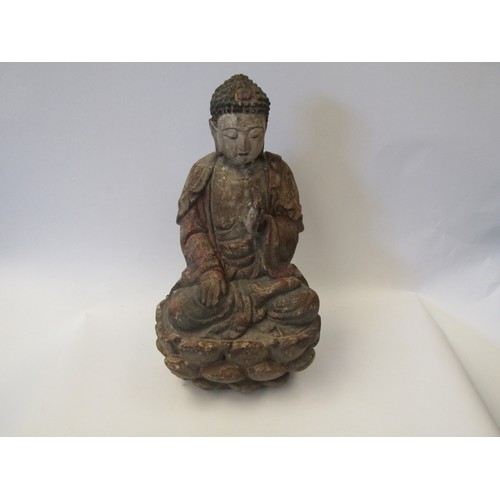 1033 - A hand-carved wooden figure figure of a Buddhist deity seated on a lotus flower, with painted facial... 