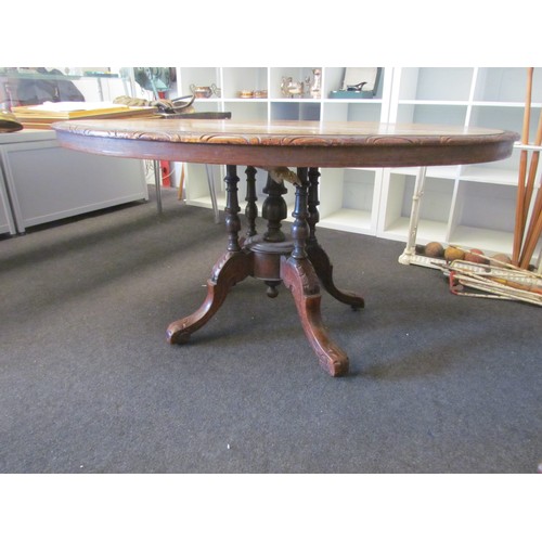 1058 - Victorian mahogany oval table top on five pillar pedestal base with scrolled feet.