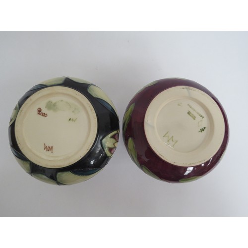 6631 - Two Moorcroft squat form vases, Trillium and Pansy pattern, monogrammed to base WM, 10.5cm tall (2)