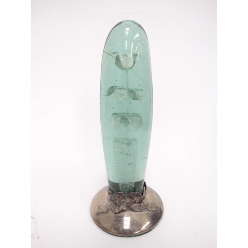 6601 - A Victorian green glass dump, elongated form with three tier flower inclusion, on a later silver bas... 