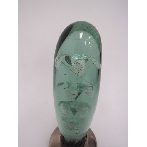 6601 - A Victorian green glass dump, elongated form with three tier flower inclusion, on a later silver bas... 