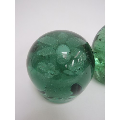 6606 - Two Victorian green glass dumps both with multiple flower inclusions, tallest a/f. 12.5cm