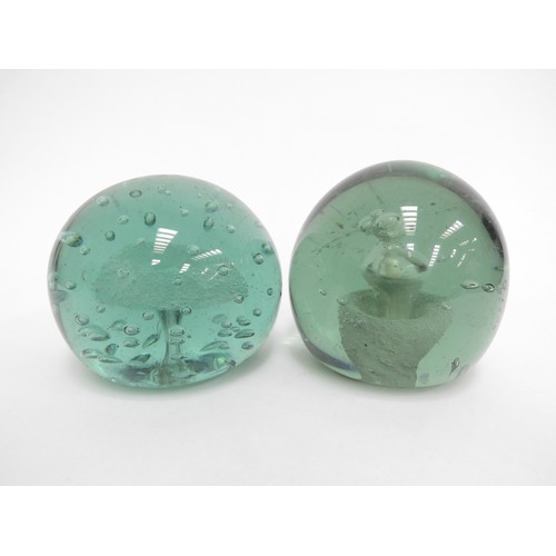 6593 - Two Victorian green glass dumps one with enclosed plaster figure the other with figure and bubble in... 