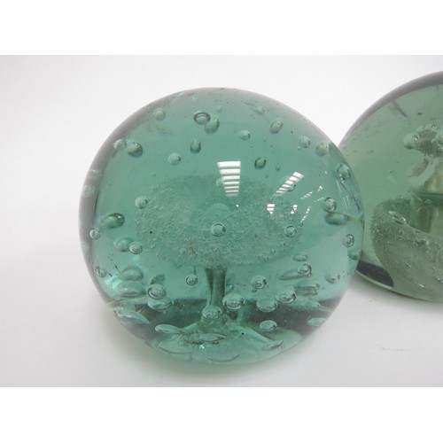 6593 - Two Victorian green glass dumps one with enclosed plaster figure the other with figure and bubble in... 