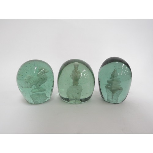 6588 - Three Victorian green glass dumps with enclosed plaster figures of a cockerel, young boy and temple,... 