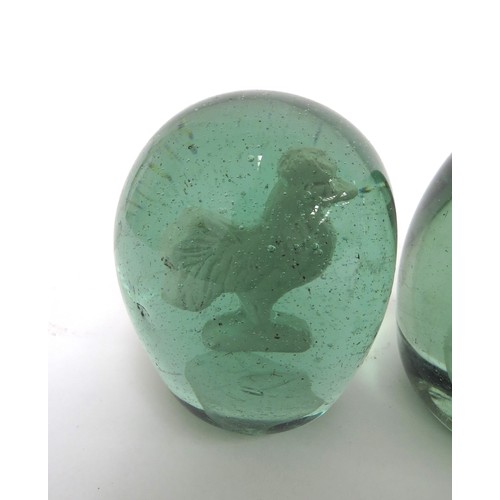 6588 - Three Victorian green glass dumps with enclosed plaster figures of a cockerel, young boy and temple,... 