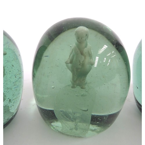 6588 - Three Victorian green glass dumps with enclosed plaster figures of a cockerel, young boy and temple,... 