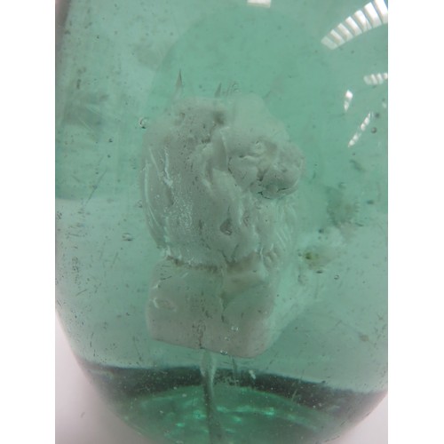 6597 - A Victorian green glass dump with an enclosed plaster figure of a Lion, 12.5cm tall