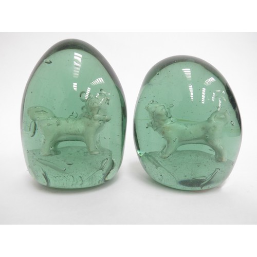 6595 - Two Victorian green glass dumps with enclosed plaster figures of Pug Dogs, 12cm tall