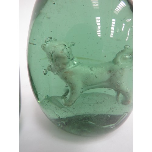 6595 - Two Victorian green glass dumps with enclosed plaster figures of Pug Dogs, 12cm tall