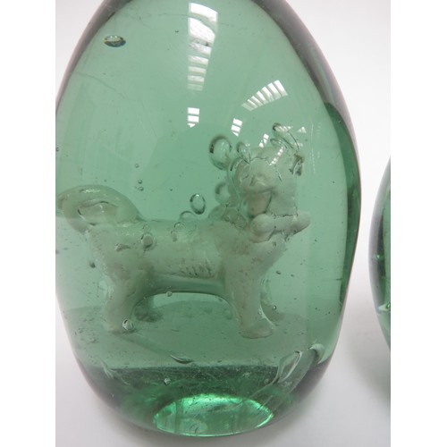 6595 - Two Victorian green glass dumps with enclosed plaster figures of Pug Dogs, 12cm tall