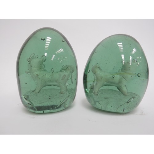 6595 - Two Victorian green glass dumps with enclosed plaster figures of Pug Dogs, 12cm tall