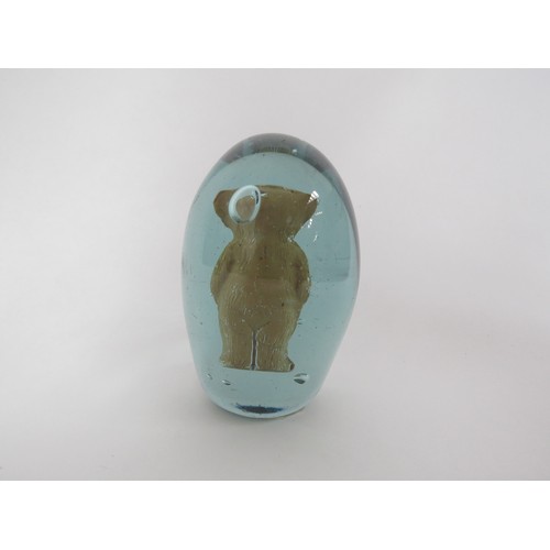 6599 - A Victorian green glass dump with an enclosed fired clay figure of a Teddy Bear, 9cm tall