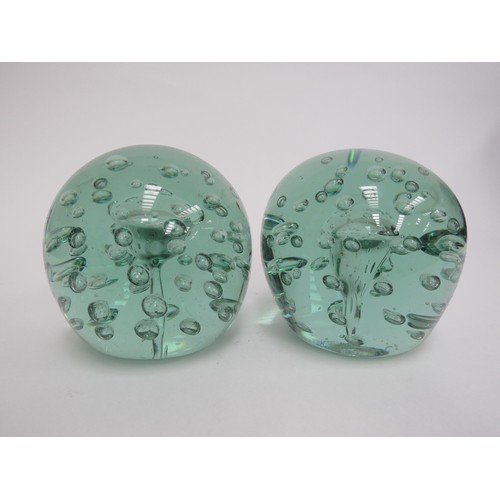 6590 - A Victorian green glass dumps both with bubble inclusions and large bubble to centres (near pair), 1... 