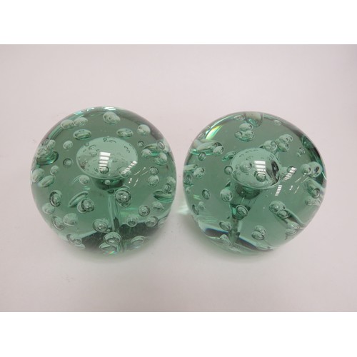 6590 - A Victorian green glass dumps both with bubble inclusions and large bubble to centres (near pair), 1... 