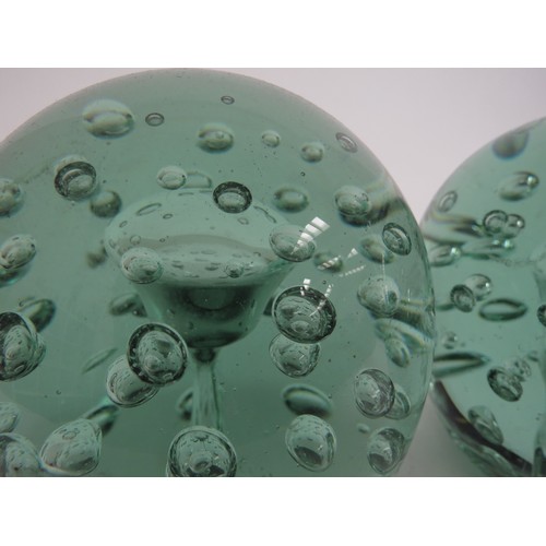 6590 - A Victorian green glass dumps both with bubble inclusions and large bubble to centres (near pair), 1... 