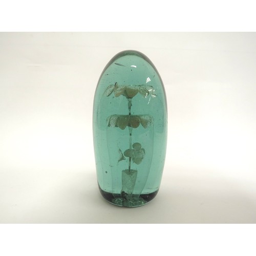 6585 - A Victorian green glass dump with three tier flower inclusion, 16cm tall