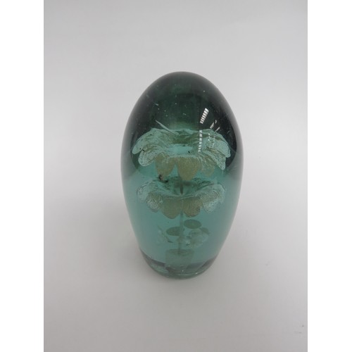 6585 - A Victorian green glass dump with three tier flower inclusion, 16cm tall