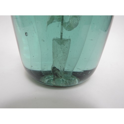 6585 - A Victorian green glass dump with three tier flower inclusion, 16cm tall