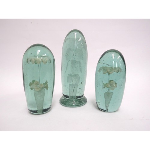 6583 - Three Victorian green glass dumps elongated form with flower and fountain inclusions, tallest 17cm