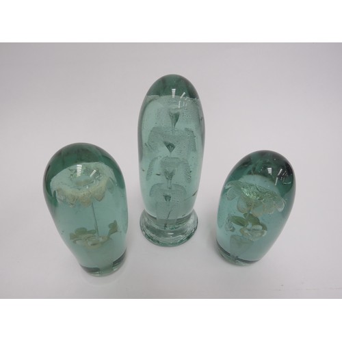 6583 - Three Victorian green glass dumps elongated form with flower and fountain inclusions, tallest 17cm