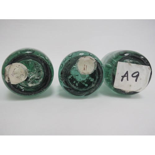 6577 - Three Victorian green glass dumps of elongated form all with bubble inclusions, tallest 14cm