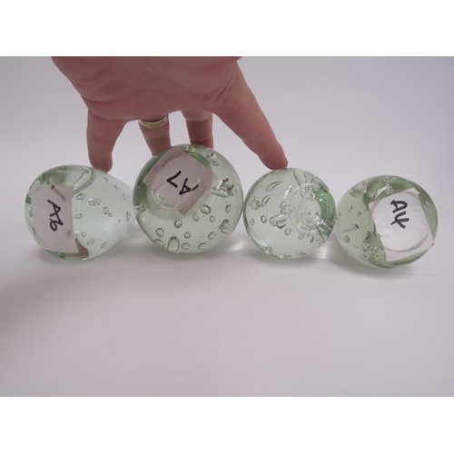 6573 - Four pale green glass dumps with bubble inclusions, tallest 9.5cm