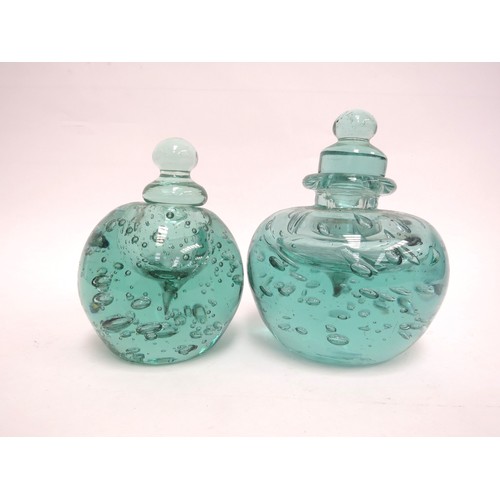 6564 - Two Victorian green dump glass inkwells with bubble inclusions, stoppers, 15cm tallest