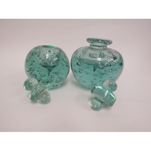 6564 - Two Victorian green dump glass inkwells with bubble inclusions, stoppers, 15cm tallest