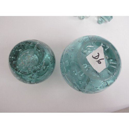 6564 - Two Victorian green dump glass inkwells with bubble inclusions, stoppers, 15cm tallest