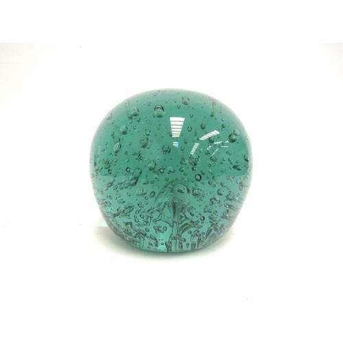 6566 - A large Victorian green dump glass doorstop with bubble inclusions, 15cm tall