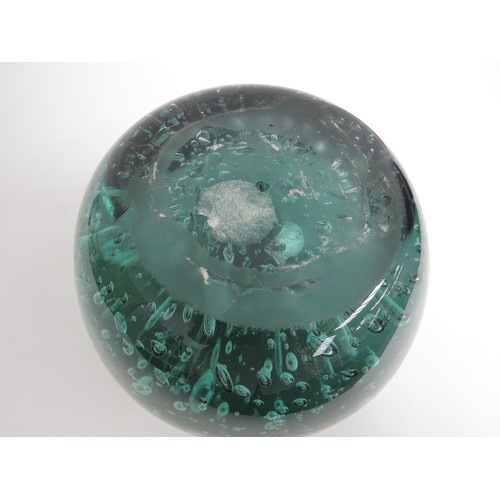 6566 - A large Victorian green dump glass doorstop with bubble inclusions, 15cm tall