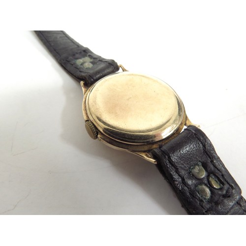 6717 - A 9ct gold wristwatch with Swiss made 15 jewel movement, cased marked N&U, manual wind, worn leather... 